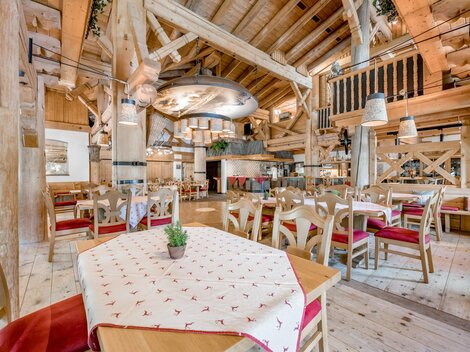 Ein rustikales Restaurant mit Holzdekor und gemütlichen Tischen. Die warmen Farben und die einladende Atmosphäre schaffen einen angenehmen Ort zum Essen.