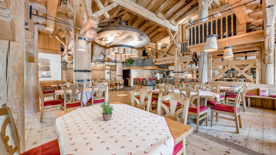 Ein rustikales Restaurant mit Holzdekor und gemütlichen Tischen. Die warmen Farben und die einladende Atmosphäre schaffen einen angenehmen Ort zum Essen.