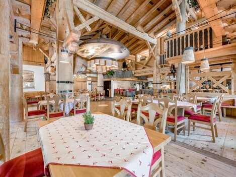 Ein rustikales Restaurant mit Holzdekor und gemütlichen Tischen. Die warmen Farben und die einladende Atmosphäre schaffen einen angenehmen Ort zum Essen.