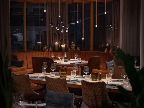 Ein elegantes Restaurant mit gemütlichen Tischen und stilvoller Beleuchtung. Die warmen Farben und das ansprechende Interieur schaffen eine einladende Atmosphäre.