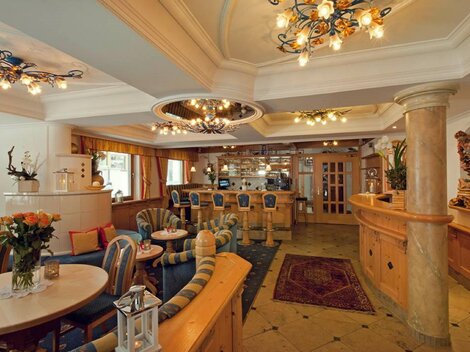 Ein elegantes Café mit gemütlichen Sitzmöglichkeiten und stilvollen Leuchten. Die Einrichtung ist warm und einladend, ideal für Entspannung und Geselligkeit.