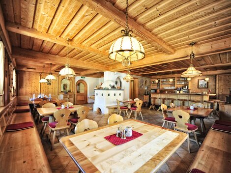 Ein gemütliches Restaurant mit Holzdekor und warmem Licht. Die Tische sind ordentlich gedeckt und bieten Platz für Gäste.